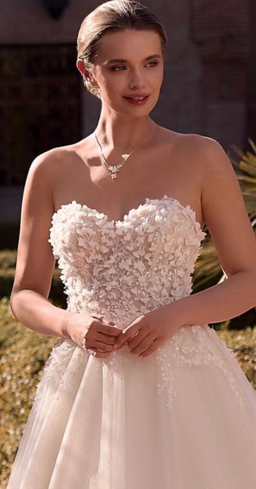 A strapless sweetheart gown with a 3D floral bodice and a soft tulle skirt